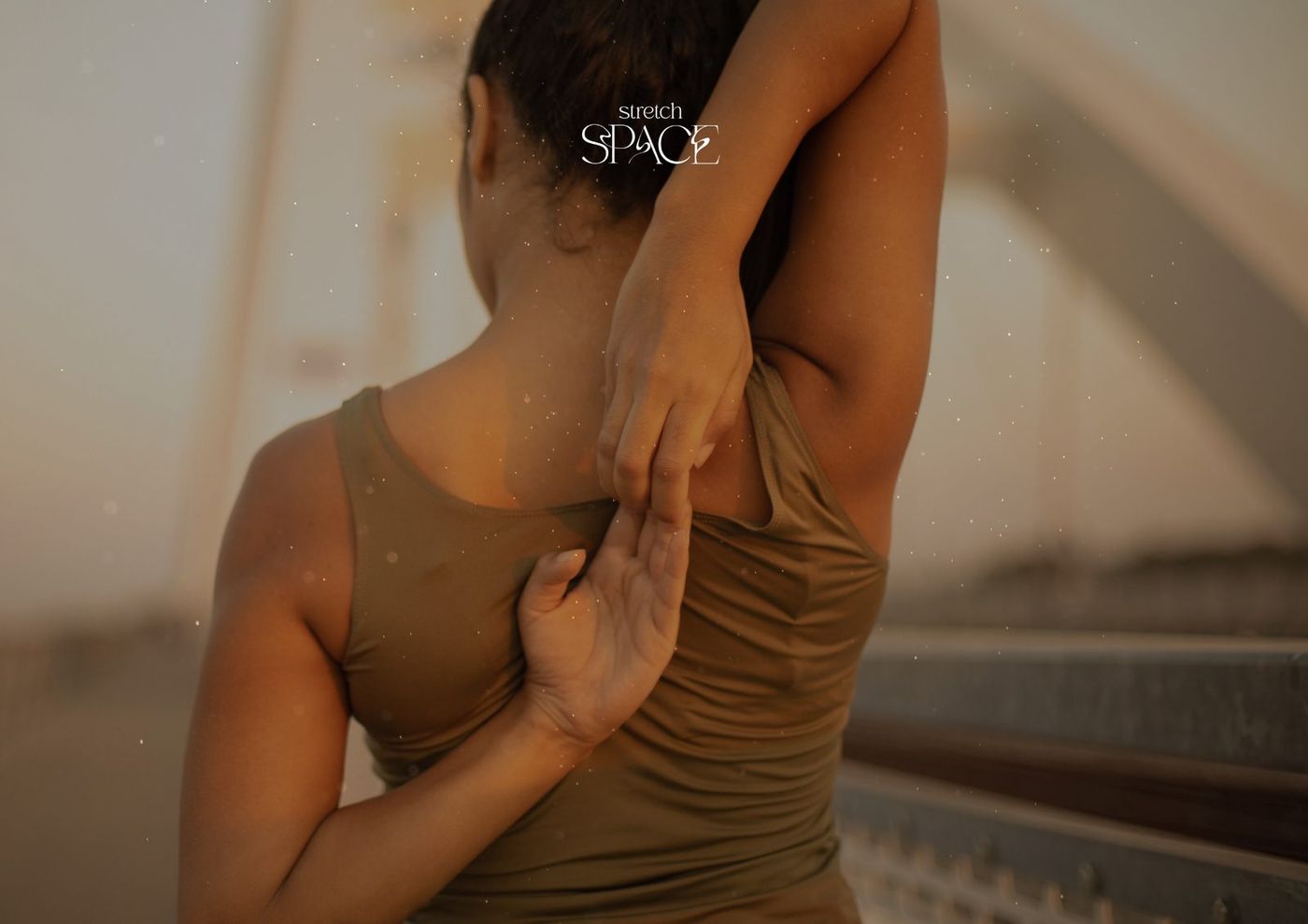 Specialist performing an assisted shoulder and upper back stretch on a seated client